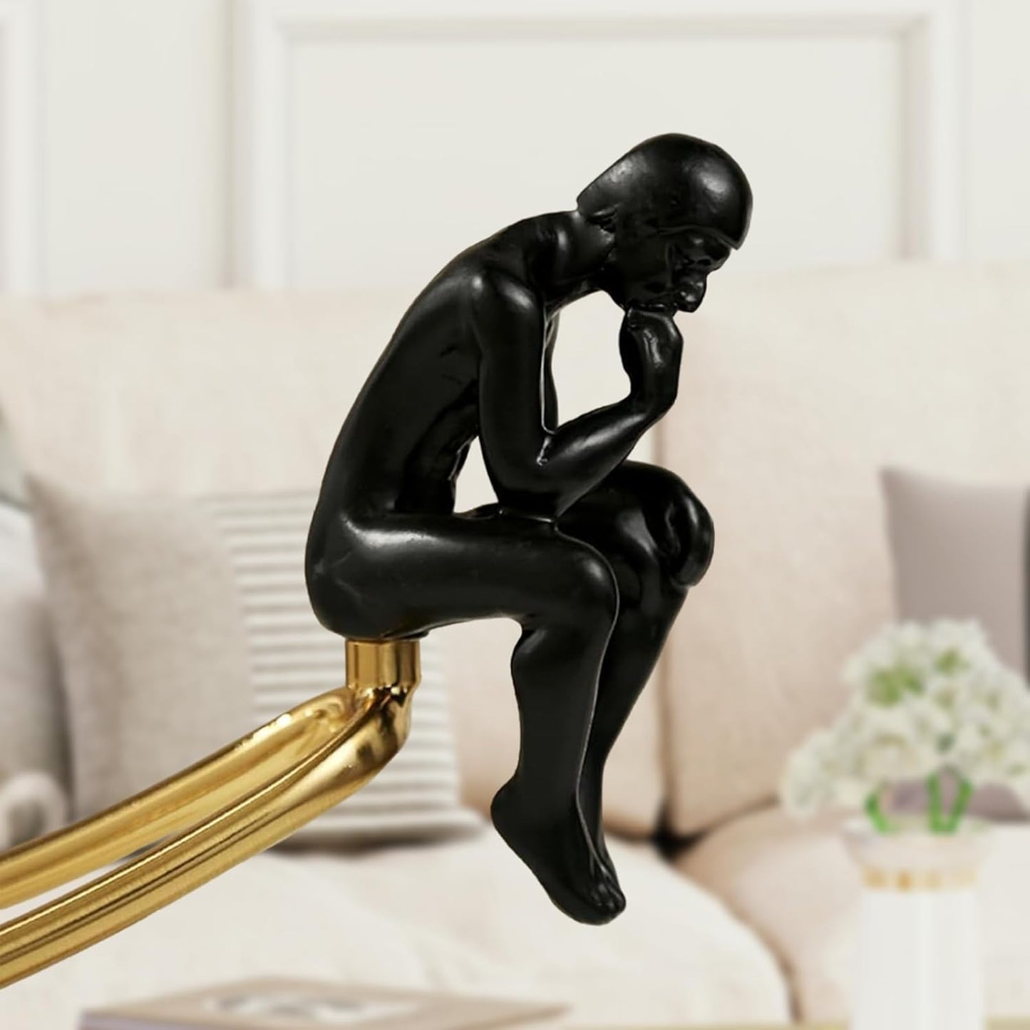 Thinker statue styled on bookshelf