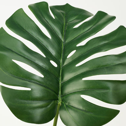 Artificial monstera plant styled in a room corner