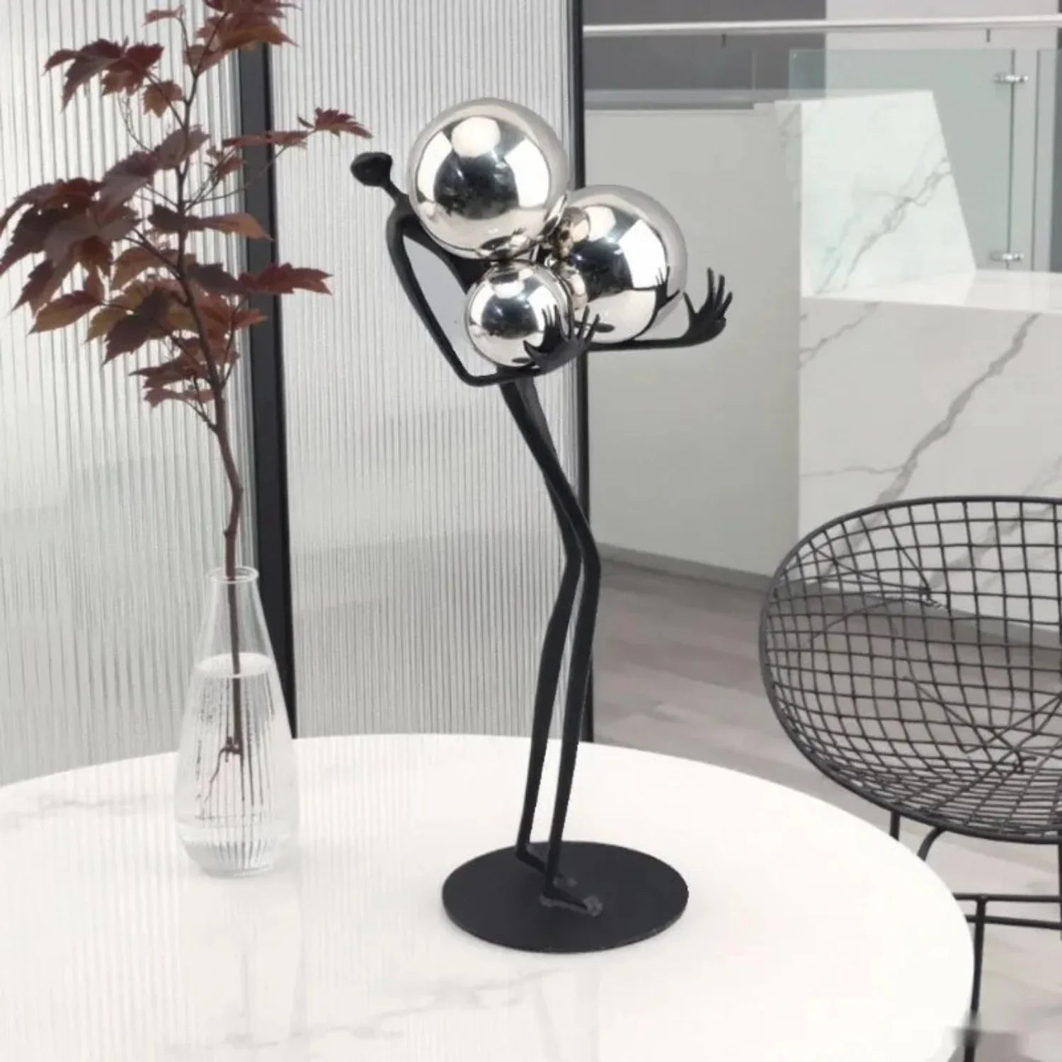 Decorative tabletop statue figure holding metal balls