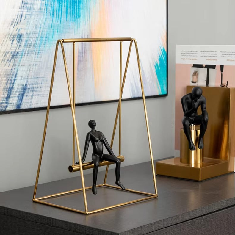 Metal swing figurine sculpture styled on bookshelf
